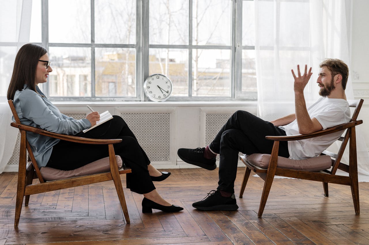 Home A therapist engaging in a counseling session with a male patient to support mental health.
