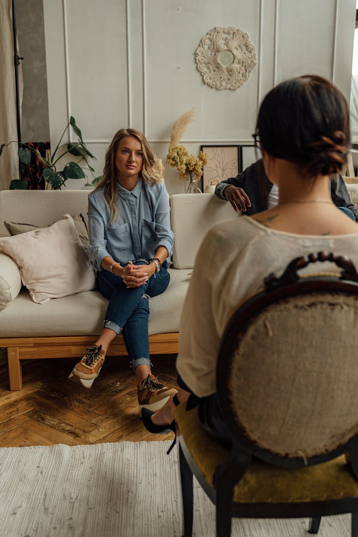 Services A therapist and client in discussion during a cozy indoor session highlighting mental health.