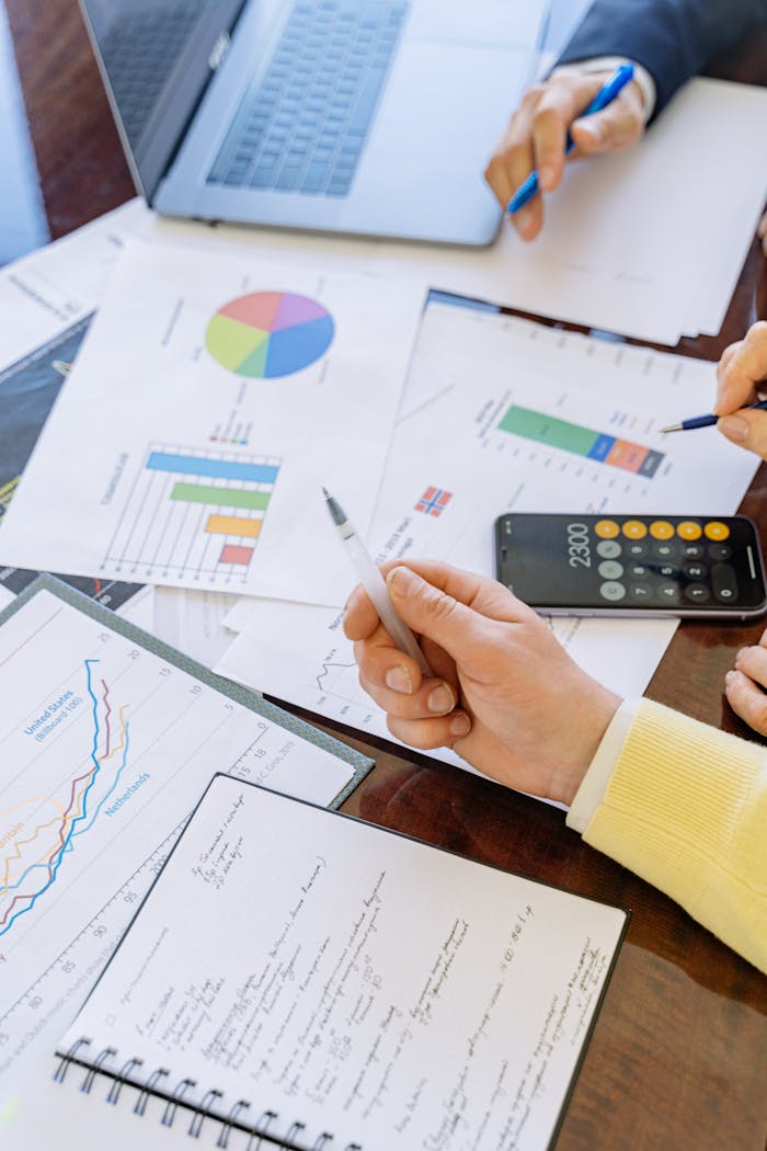 Crafting Captivating Headlines: Your awesome post title goes here A close-up of businesspeople analyzing financial data and charts during a meeting.